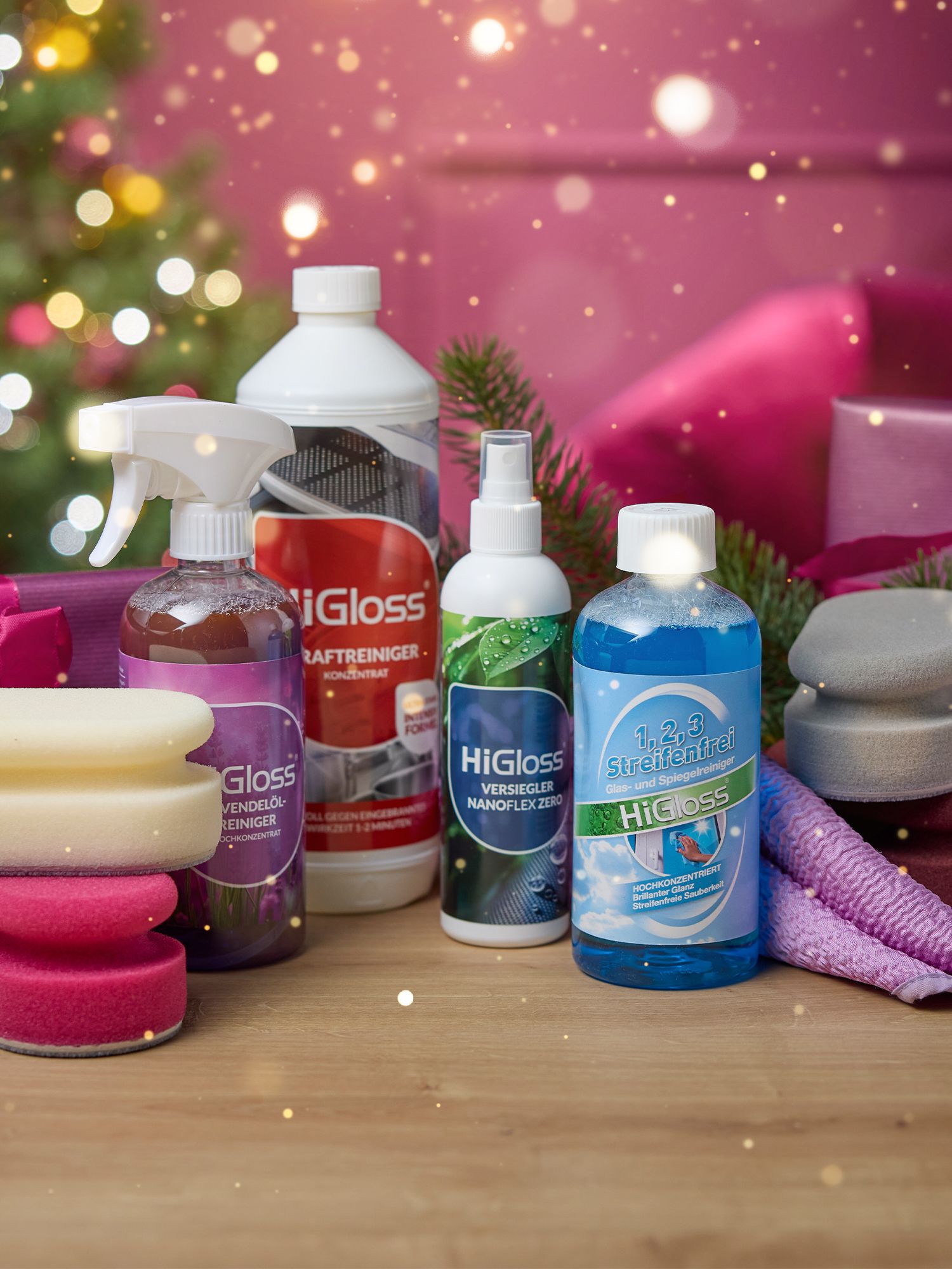 Sauber zum Fest Mehrere HiGloss-Reinigungsflaschen in verschiedenen Formen und Farben auf einem Holztisch, umgeben von Schwämmen und Tüchern, unscharfer Hintergrund mit Weihnachtsbeleuchtung.